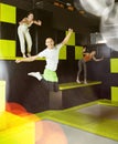 Joyful young man jumping on trampolines in colorful amusement park