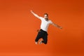 Joyful young man in casual white t-shirt posing isolated on orange wall background studio portrait. People sincere Royalty Free Stock Photo