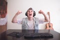 Joyful young man playing computer games at home at the computer. Portrait of a happy gamer who won the game