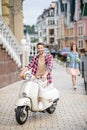 Joyful young man riding his white scooter Royalty Free Stock Photo
