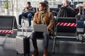 Joyful young man using laptop in departure lounge