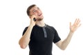 Joyful young man waving a hand looks up and speaks on a mobile phone Royalty Free Stock Photo