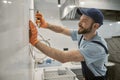 Cheerful male builder pulling out nail with pliers