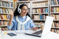 Excited student celebrating success with laptop in library Royalty Free Stock Photo