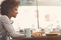 Joyful young stylish woman is spending time in cafe