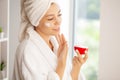 Joyful young woman applying moisturizing cream on face Royalty Free Stock Photo