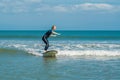 Joyful young woman beginner surfer with blue surf has fun on small sea waves. Active family lifestyle, people outdoor