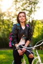 Joyful young woman on bicycle in green park on sunset Royalty Free Stock Photo