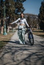 Active woman enjoying a sunny day while walking with her bicycle in the park. Royalty Free Stock Photo