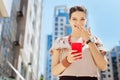 Joyful young woman holding her mobile phone