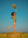 Joyful young woman jumping on hay stack Royalty Free Stock Photo