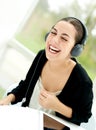 Joyful young woman laughing and listening to music