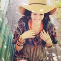 Joyful young woman portrait with dreadlocks dressed in boho style dress and necklace, sunny outdoor