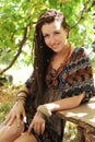 Joyful young woman portrait with dreadlocks dressed in boho style dress and necklace, sunny outdoor Royalty Free Stock Photo