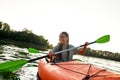 Joyful young woman smiling, enjoying a day kayaking together with her friend in a lake on a late summer afternoon Royalty Free Stock Photo