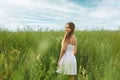 Joyful young woman in sundress in the field turning back Royalty Free Stock Photo