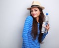 Joying casual woman in summer hat holding bottle of pure water a Royalty Free Stock Photo