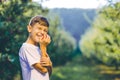 Joyous boy biting fresh red apple, enjoying time in autumn garden. Royalty Free Stock Photo