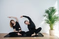 Joyous couple stretching next to each other, sitting on a single mat Royalty Free Stock Photo