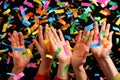 Joyous hands celebrating with colorful confetti at concert Royalty Free Stock Photo