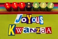 JOYOUS KWANZAA text word collage typography, seven candles and multi colored fabric on green woven fabric, African American holida Royalty Free Stock Photo