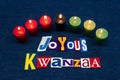 JOYOUS KWANZAA word text collage typography, seven candles and multi colored fabric on blue denim, African American holiday Royalty Free Stock Photo