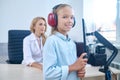 Joyous young girl in headsets undergoing a hearing screening procedure