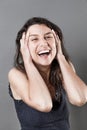 Joyous young woman bursting out laughing