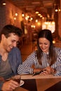 Joyously happy millenial couple in restaurant