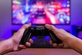 Joypad in hands. Gaming concept. Computer display with racing game and rgb light in background Royalty Free Stock Photo