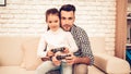 Joystick in Hand. Father and Daughter. Spend Time Together. Father`s day. Man Playing with Girl. Video Game. White Interior. Royalty Free Stock Photo