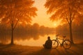Man with bicycle enjoying a serene autumn sunset by a calm lake reflection with golden trees Royalty Free Stock Photo