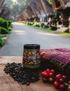 Toraja Coffee in Traditional Carved Mug with Tenun and Tongkonan Houses Royalty Free Stock Photo