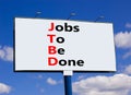 JTBD jobs to be done symbol. Concept words JTBD jobs to be done on white billboard against beautiful blue sky and white clouds.