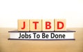 JTBD jobs to be done symbol. Concept words JTBD jobs to be done on wooden blocks and book on beautiful white background. Business