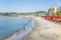 Juan Le Pen, France, 10/06/2019: Sandy beach on the turquoise sea with sunbeds and hotels in the southern resort town