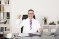 Jubilant doctor sitting cheering in his office