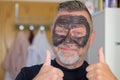 Jubilant man doing a skin care treatment using a face mask