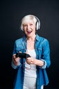 Jubilated senior woman playing video games