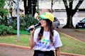 Juciane Cunha at the microphone in the city square on labor day