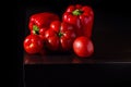 Jucy bell peppers and fresh tomatoes on dark wooden background