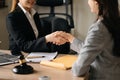 Judge and client shaking hands and lawyers discussing contract papers after adviced in background at courtroom, lawyer service Royalty Free Stock Photo