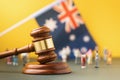 Judge gavel against a blurred Australian flag and plastic toy men background, Australian society litigation concept Royalty Free Stock Photo