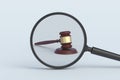 Judge gavel behind magnifying glass