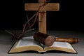 Judge gavel, bible, wooden cross and crown of thorns on grey table