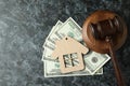 Judge gavel, dollars and wooden house on black smokey table Royalty Free Stock Photo
