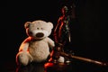 Judge gavel, figure of lady of justice and teddy bear in a dark court room. Law protection and children concept Royalty Free Stock Photo