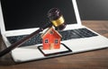 Judge gavel and house model on the computer keyboard Royalty Free Stock Photo