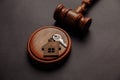 Judge gavel and key chain in shape of two splitted part of house on wooden background. Concept of real estate auction or Royalty Free Stock Photo