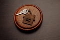 Judge gavel and key chain in shape of two splitted part of house on wooden background. Concept of real estate auction or